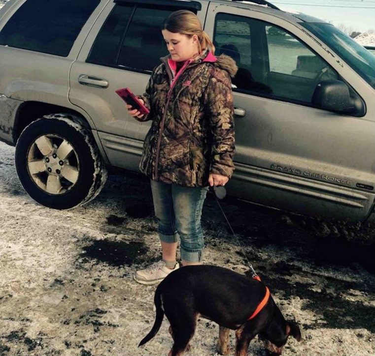 Nicole Bizier, 32, stands by her silver Jeep in the Pizza Hut parking lot with the puppy she tried to sell to state animal welfare agents and Skowhegan police on Feb. 2.