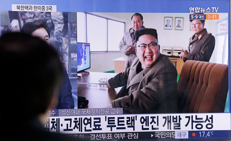 A man at a Seoul railway station watches a TV news program Sunday showing an image, published in North Korea's Rodong Sinmun newspaper, of North Korean leader Kim Jong Un at the country's Sohae launch site.