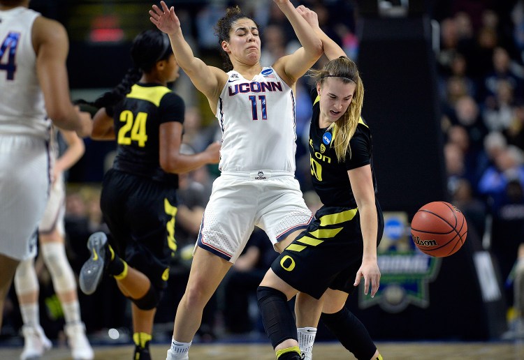 Oregon's Sabrina Ionescu tries to gather the ball after running into the defense of Connecticut's Kia Nurse in the first half of Monday night's regional final in Bridgeport, Conn. Connecticut advanced to the Final Four for the tenth straight year.