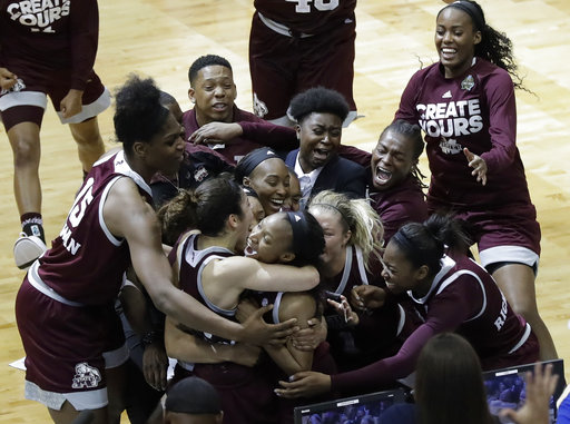 Mississippi State guard Morgan William, center, celebrates with teammates after she hit the winning shot at the buzzer in overtime to defeat Connecticut.