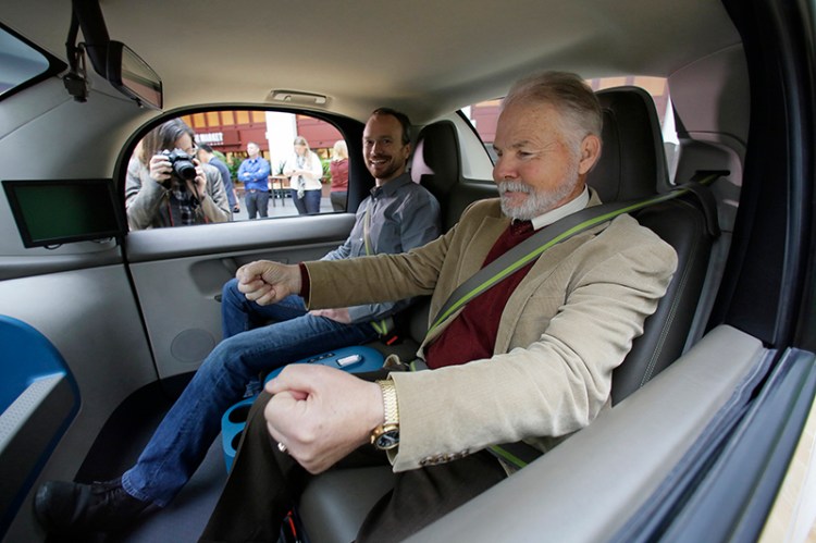 Steve Mahan, who is blind, gestures for a steering wheel that doesn't exist inside a Waymo driverless car in San Francisco in 2016.