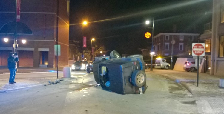 A Jeep rests on its side on High Street In Portland on Saturday night.