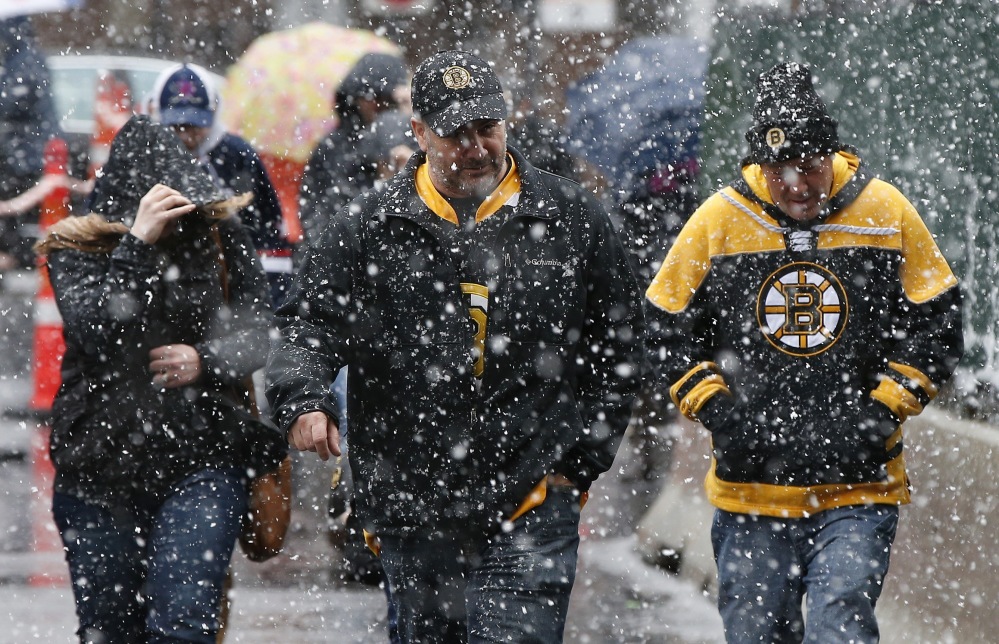 Boston Bruins fans walk to the game against the Florida Panthers at TD Garden as snow falls Saturday in Boston. The fans who braved the April Fool's storm were rewarded with a 5-2 Bruins win. (Associated Press/Michael Dwyer)