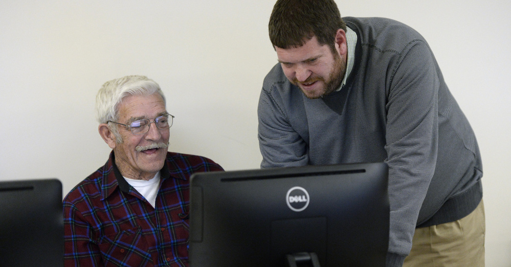 Michael Lamoureux works with Bill Kiley, 80, during a technology class in Gray. Kiley owns a computer but didn't know how to navigate it before taking the course.