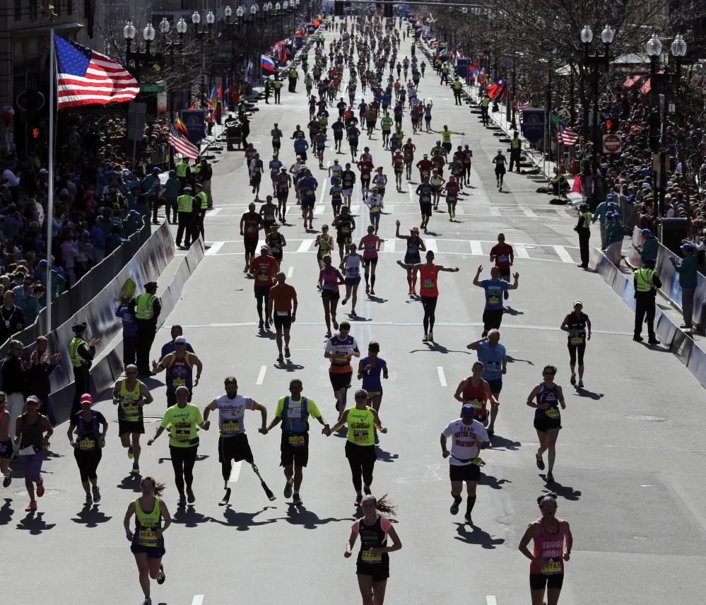 Runners approach the finish line of the 120th Boston Marathon on April 18, 2016, in Boston. Organizers of the 2017 race said the April 17 event will pump more than $192 million into the local economy, including $30 million for dozens of charities.