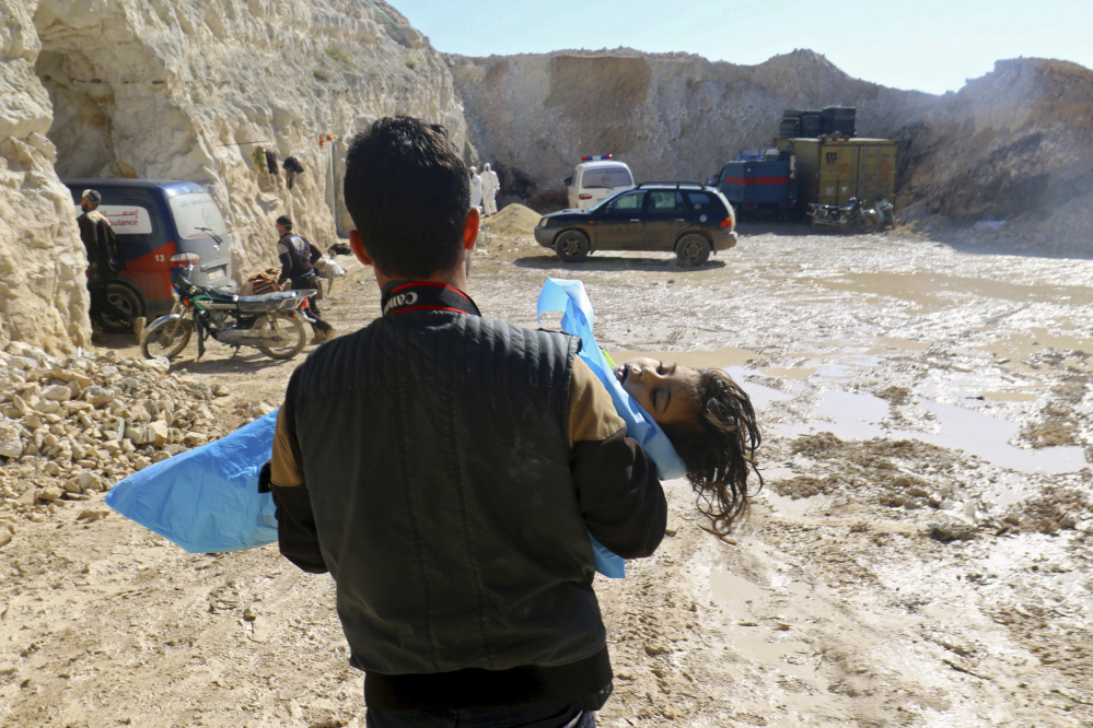 A man carries the body of a dead child Tuesday after what rescue workers described as a suspected gas attack in the town of Khan Sheikhoun in rebel-held Idlib, Syria.