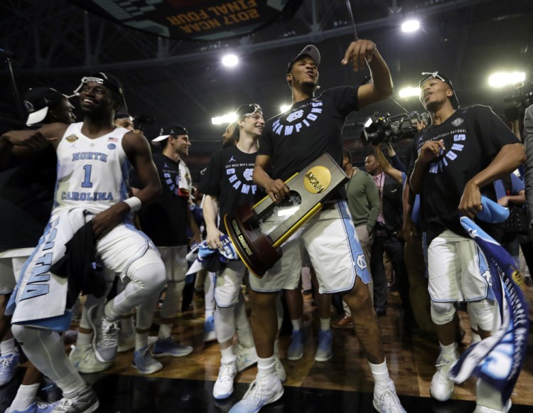 North Carolina's Kennedy Meeks holds the championship trophy as he celebrates with his teammates after defeating Gonzaga 71-65 in the NCAA men's basketball final Monday.