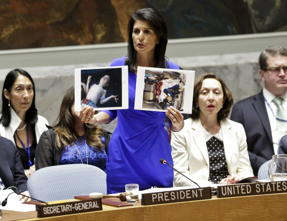 Nikki Haley, the U.S. ambassador to the United Nations, shows pictures of Syrian victims of Tuesday's chemical attack as she addresses a meeting of the Security Council on Wednesday. The council met in an emergency session to consider a resolution to back an investigation and compel the Syrian government to cooperate.