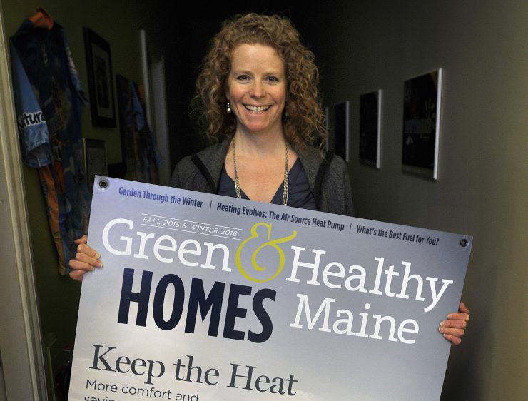 Heather Chandler, founder of the Sunrise Guide, shows off a poster of the cover of Green & Healthy Maine Homes, a magazine that she publishes.