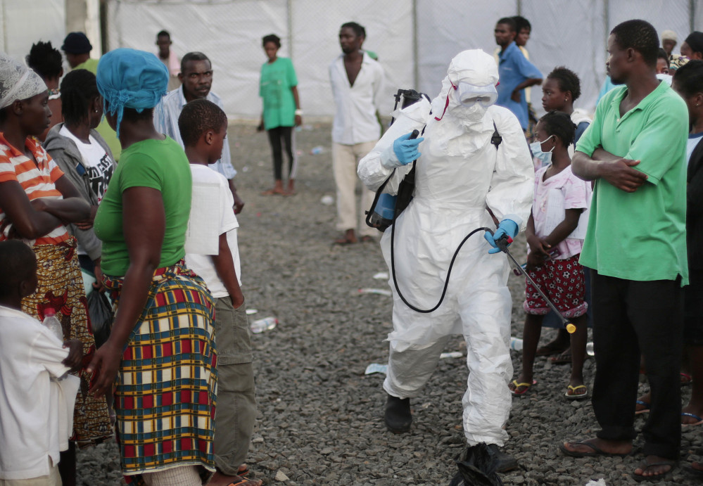 A medical worker sprays people at an Ebola treatment center in Liberia in 2014. A once busy treatment unit in Paynesville, Liberia, was decommissioned Wednesday.
