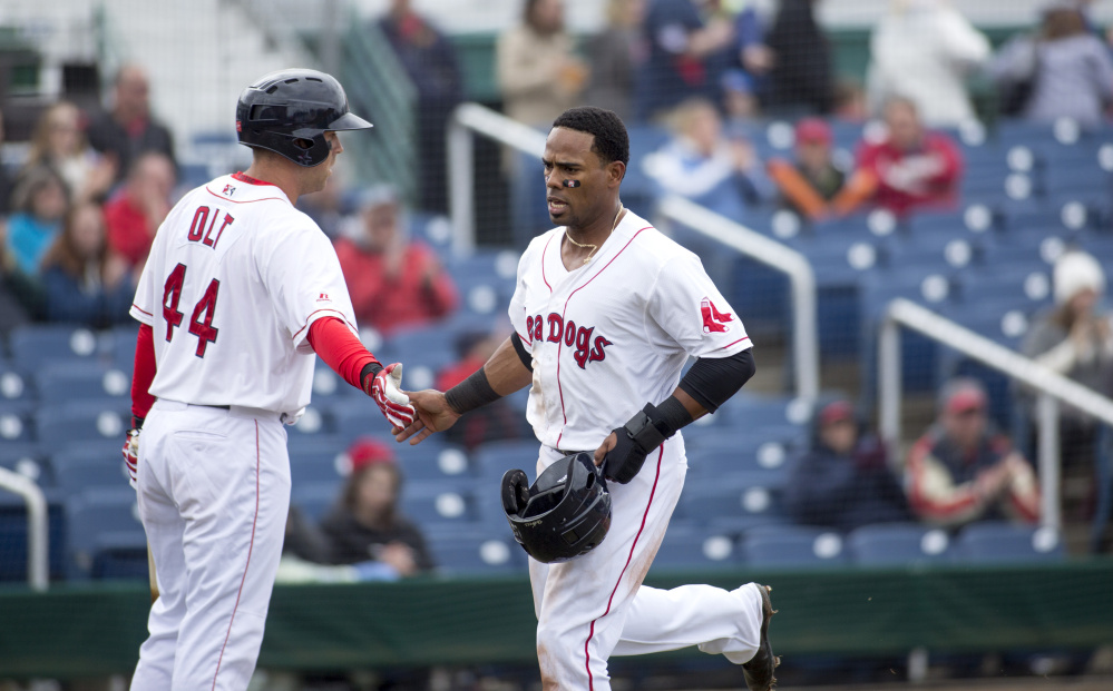 PORTLAND, ME - APRIL 8: Sea Dog's Aneury Tavarez (20) high fives his teammate Mike Olt (44) as he runs into home during the game against the Reading Fighting Phils. The Sea Dogs won (4-1). (Staff photo by Brianna Soukup/Staff Photographer)