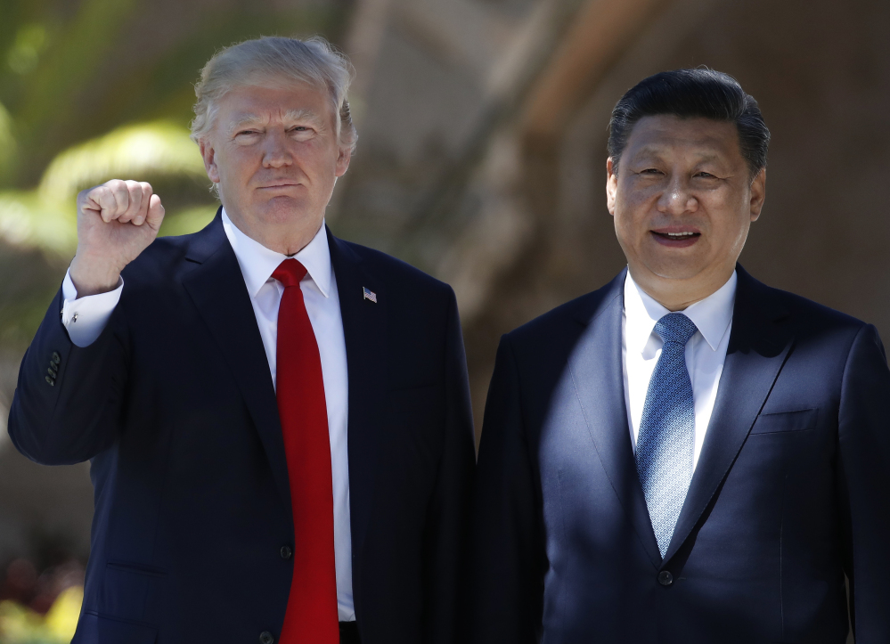 President Donald Trump and Chinese President Xi Jinping pause for photographs at Mar-a-Lago in Palm Beach, Fla., on Friday. 