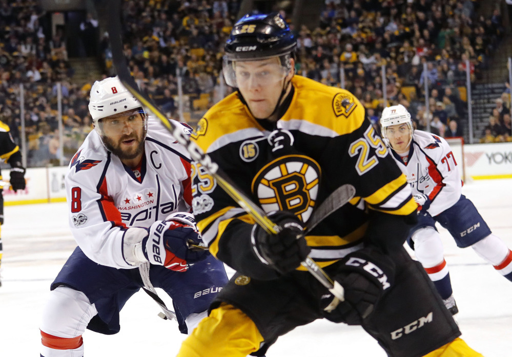 Alex Ovechkin of the Capitals moves in to check Bruins defenseman Brandon Carlo into the boards in the first period Saturday at TD Garden. Carlo was injured and did not return, and the Bruins lost, 3-1.