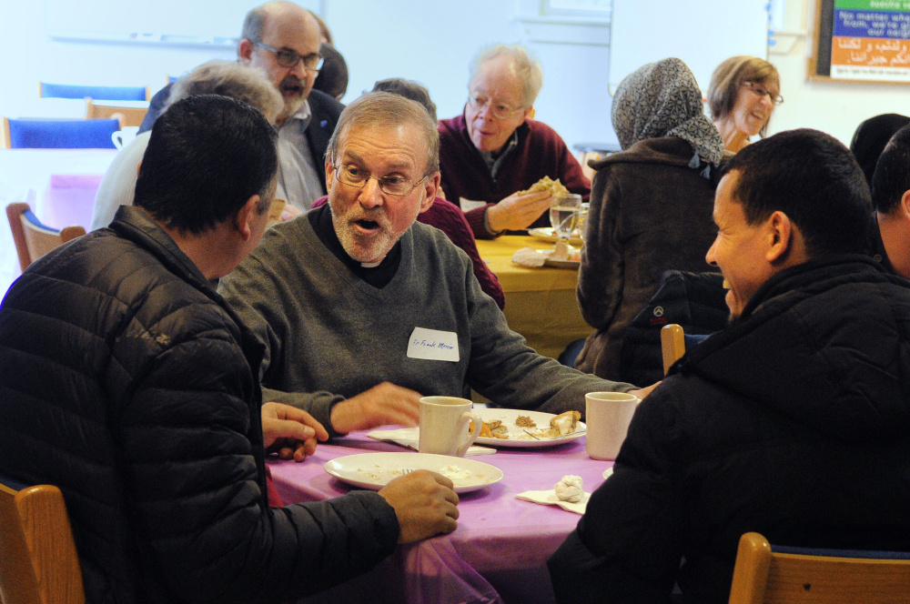 Adnan Kadhim, left, the Rev. Frank Morin, and Hassan Nasar chat over lunch on Saturday at Prince of Peace Lutheran Church in Augusta during a meeting to discuss creating a community center to welcome new residents.