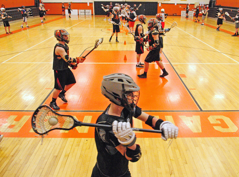 The Gardiner boys lacrosse team runs through drills during practice Tuesday at Gardiner Area High School.
