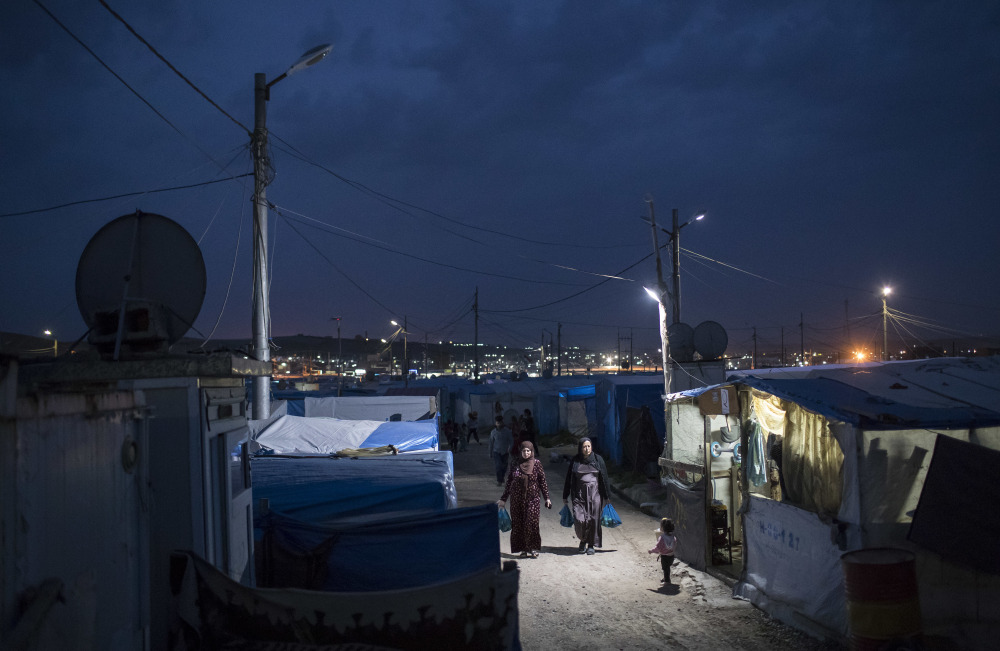 Syrian women walk at dusk in a refugee camp in northern Iraq on Saturday. For millions of refugees, the chemical attack in Syria followed by the U.S. strike was a rare moment when the world briefly turned its attention to Syria, before turning away again.