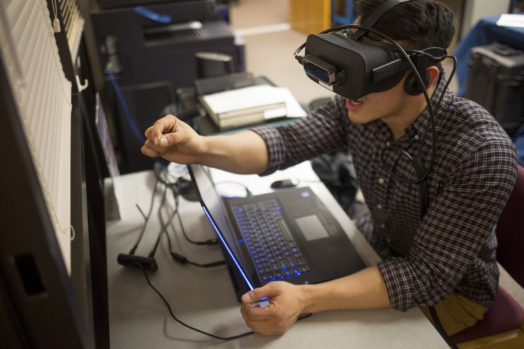 Ryan Hoang, a first-year medical student at UNE, experiences how just grasping a pencil can be challenging when you're suffering from macular degeneration, courtesy of virtual reality software. "It lets you experience the reality of having no control," Hoang said.