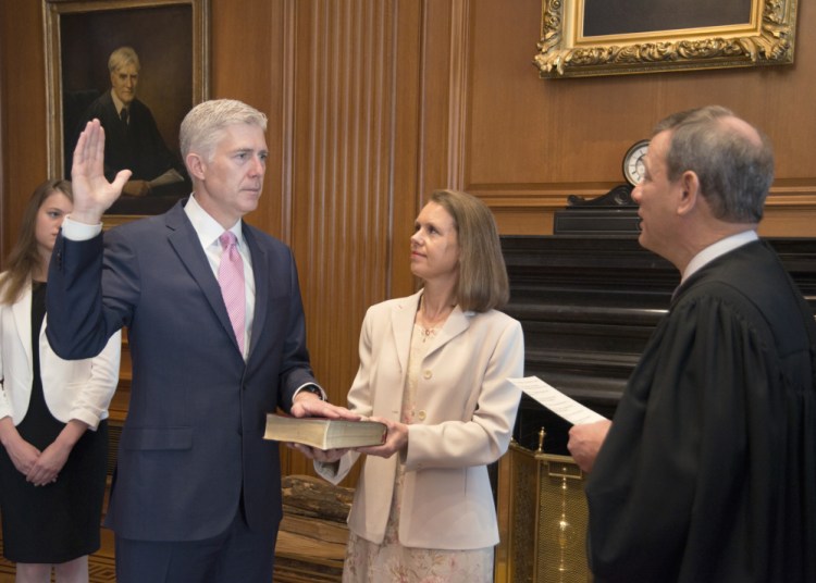 U.S. Chief Justice John G. Roberts Jr. administers the Constitutional Oath to the Neil Gorsuch in a private ceremony attended by the justices of the Supreme Court and members of the Gorsuch family, including his wife, Louise Gorsuch, on Monday in Washington.