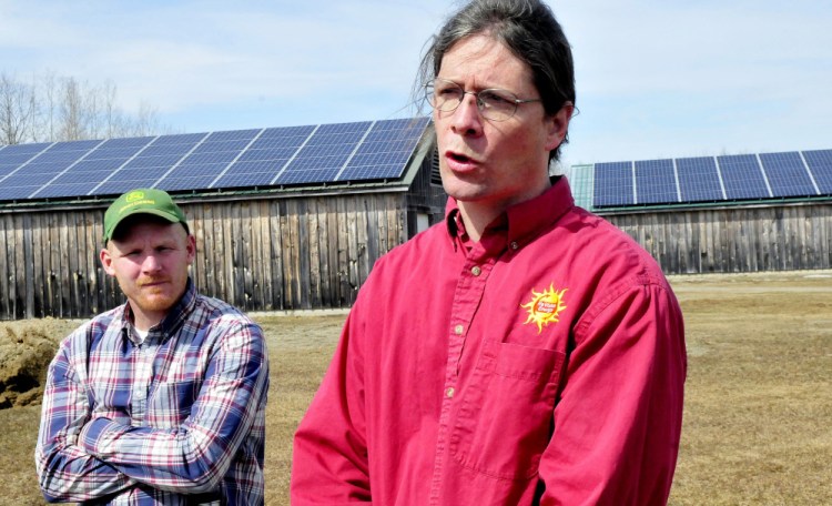 John Luft, right, of ReVision Energy, speaks about the solar system that generates electricity for the Maine Organic Farmers and Gardeners Association in Unity on Monday. At left is MOFGA facilities director Jason Tessier.