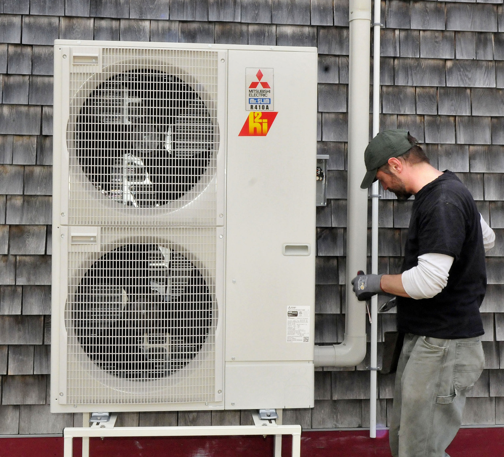 Ren Floyd of ReVision Energy installs a heat pump at the Common Ground Education Center at the Maine Organic Farmers and Gardeners Association in Unity on Monday.
