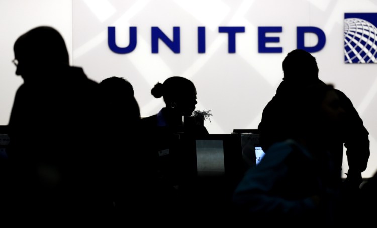 Travelers check in at the United Airlines ticket counter at O'Hare International Airport in Chicago, where a passenger who refused to give up his seat because of overbooking was dragged off the plane by police Sunday.