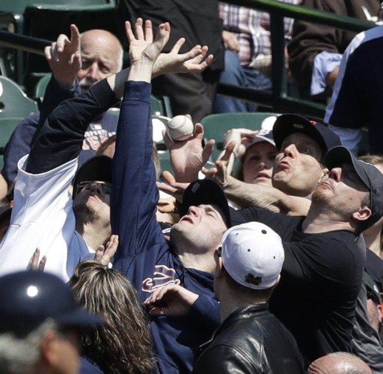 Baseball fans at Detroit's Comerica Park present an array of hands and facial expressions as they reach for a foul ball off the bat of Minnesota's Jorge Polanco during a 5-3 comeback win by the Tigers on Wednesday afternoon.