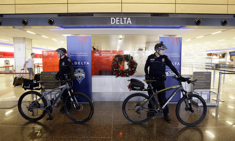 Police officers stand ready at Seattle-Tacoma International Airport last year. A police research group says airlines should think carefully before asking police to intervene.