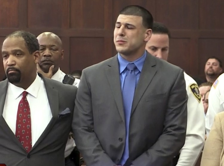In this image from video, Aaron Hernandez, right, listens beside defense attorney Ronald Sullivan in court in Boston on Friday, as he is pronounced not guilty of murder in the 2012 shootings of two men in a drive-by shooting in Boston.