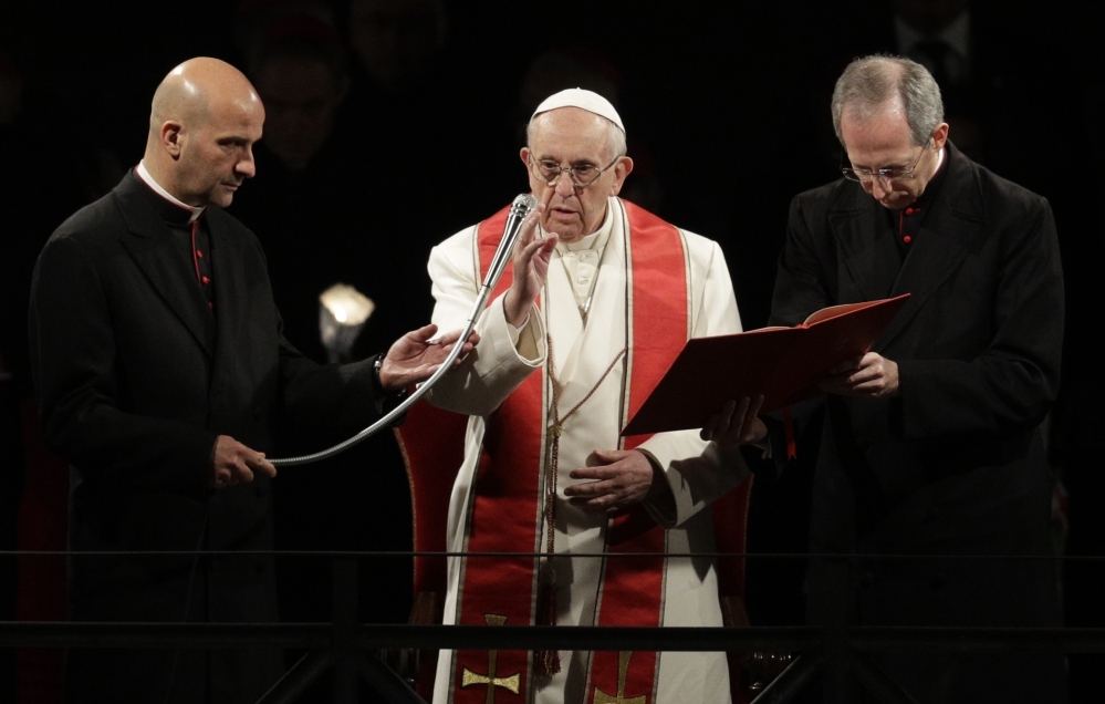 Pope Francis delivers his blessing as he presides over the Way of the Cross torchlight procession on Good Friday in front of Rome's Colosseum.