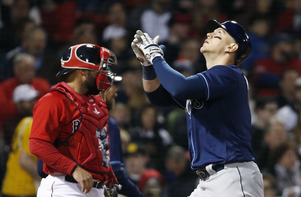 Logan Morrison of the Tampa Bay Rays celebrates after hitting a grand slam Friday night in front of catcher Sandy Leon of the Boston Red Sox during the third inning of the Rays' 10-5 victory at Fenway Park.