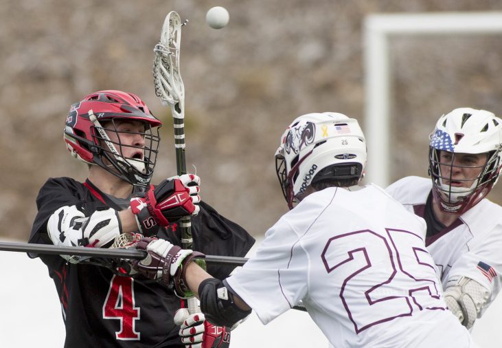 Scarborough's Marc Guerette passes the ball to a teammate as Mat Anderson, front, of Gorham defends during their boys' lacrosse season opener Saturday at the University of Southern Maine. Guerette was one of seven goal scorers for the Red Storm in a 15-9 victory.