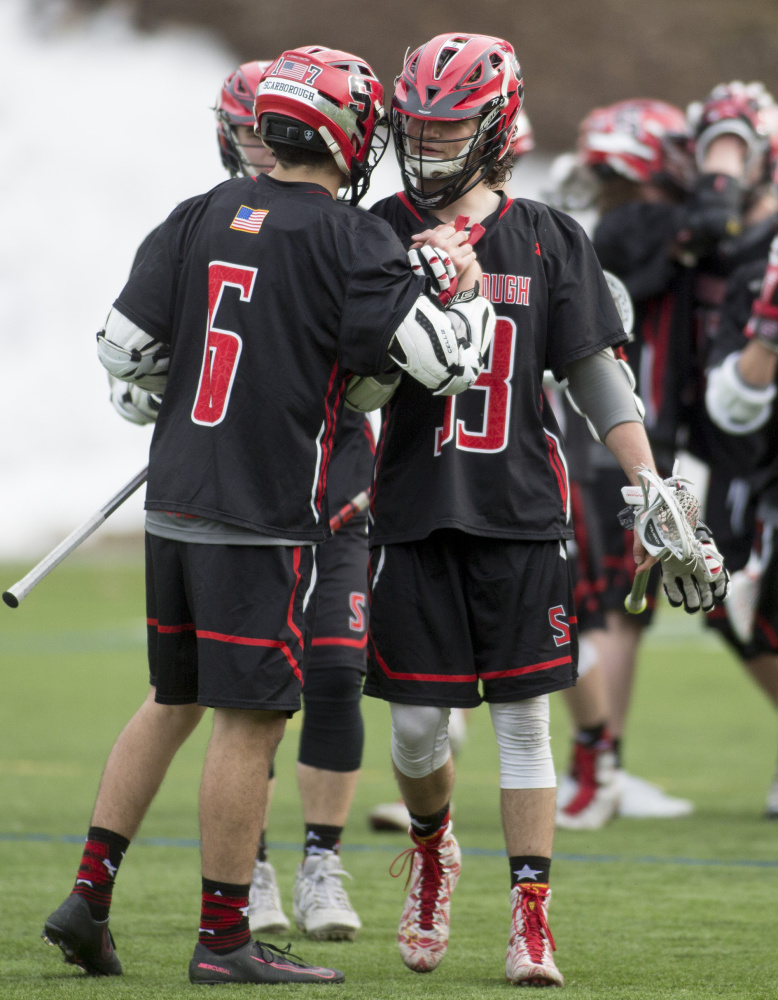 Marco Manfra, left, celebrates with Drew Cusson after one of his three goals for Scarborough. The Red Storm began defense of their Class A state championship by defeating a Gorham team that reached the regional final last year.