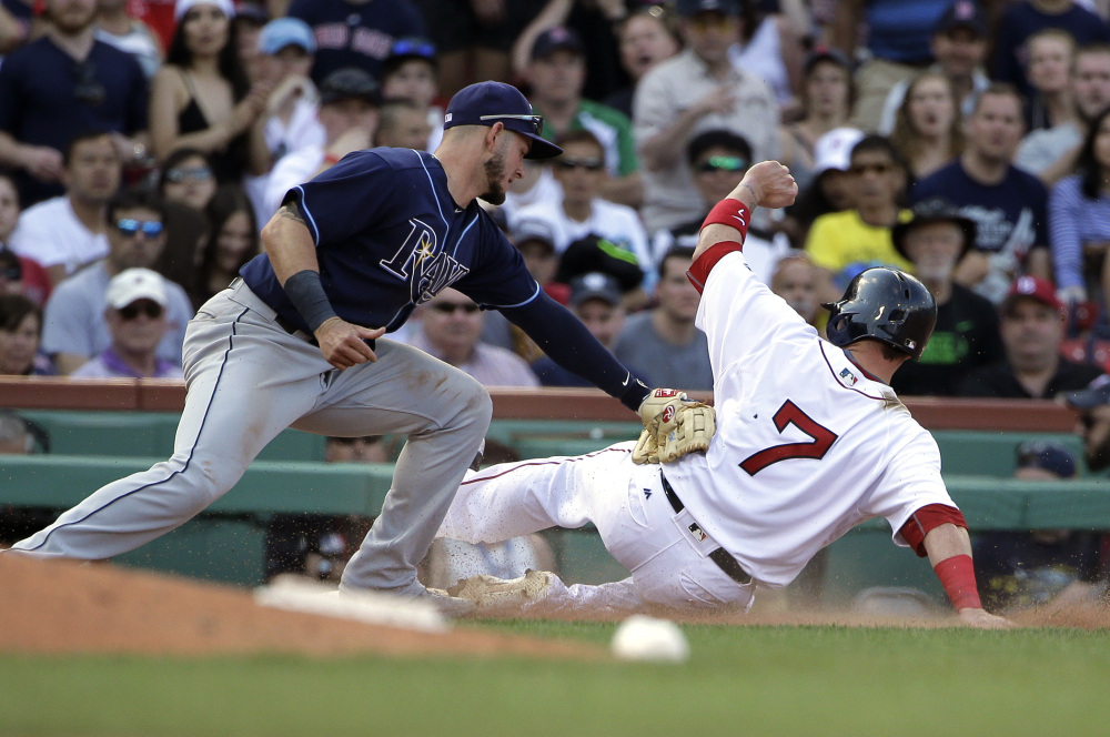 Tampa Bay's Daniel Robertson tags out Boston's Christian Vazquez, who tried to advance to third on a fly ball in the eighth inning Sunday at Fenway Park. Vazquez went 3 for 4 with an RBI double in Boston's 7-5 win.
