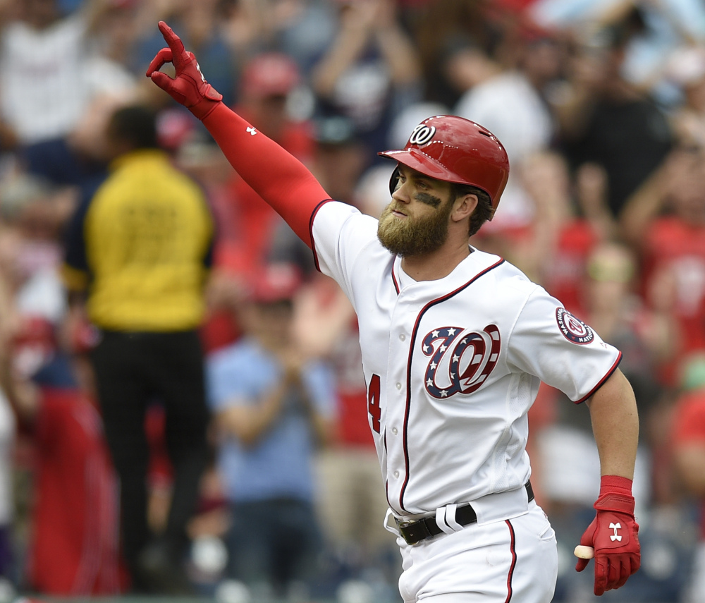 Bryce Harper celebrates after he hit a three-run homer in the ninth inning to give the Nationals a 6-4 win over Philadelphia on Sunday in Washington.
