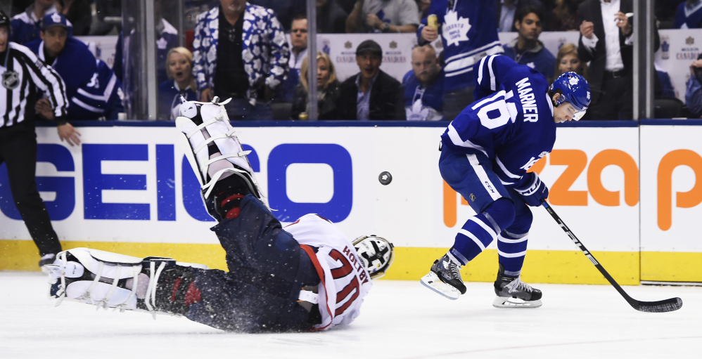 Washington goalie Braden Holtby dives at the puck in front of Toronto's Mitch Marner during the second period of a 4-3 overtime win by the Maple Leafs Monday at Toronto.