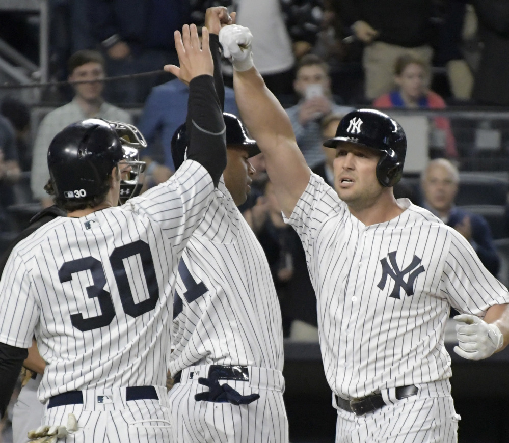 New York's Matt Holliday, right, celebrates with Aaron Hicks, center, and Pete Kozma after Holliday hit a three-run home run in the third inning of a 7-4 win by the Yankees at New York on Monday.