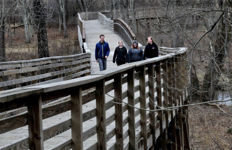 Unity College students cross the Community Bridge, near the beginning of they trail.