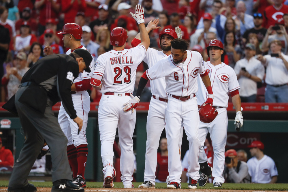 Adam Duvall of the Cincinnati Reds celebrates with his teammates Tuesday night after hitting a second-inning grand slam. The Reds defeated the Baltimore Orioles, 9-3.