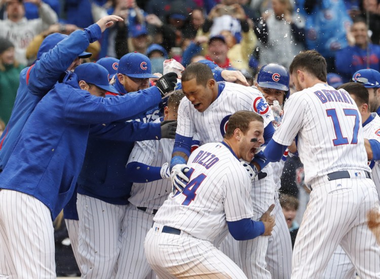 Addison Russell, center, of the Chicago Cubs celebrates with teammates after hitting a game-winning three-run homer in the ninth inning of a 7-4 win Wednesday in Chicago.
