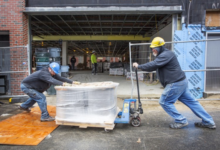 Marc Arsenault, left, and Alan Nielsen of B.H. Milliken work on a construction site at the Hiawatha building in Portland on Friday. Construction was one of the sectors that showed strong employment gains in Maine during March.