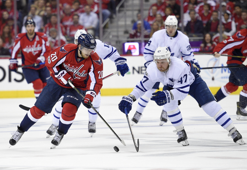 Washington's Lars Eller, left, battles for the puck with Toronto's Leo Komarov. The Capitals grabbed a 3-2 series lead with a 2-1 overtime victory and can advance to the second round with a win Sunday in Toronto.