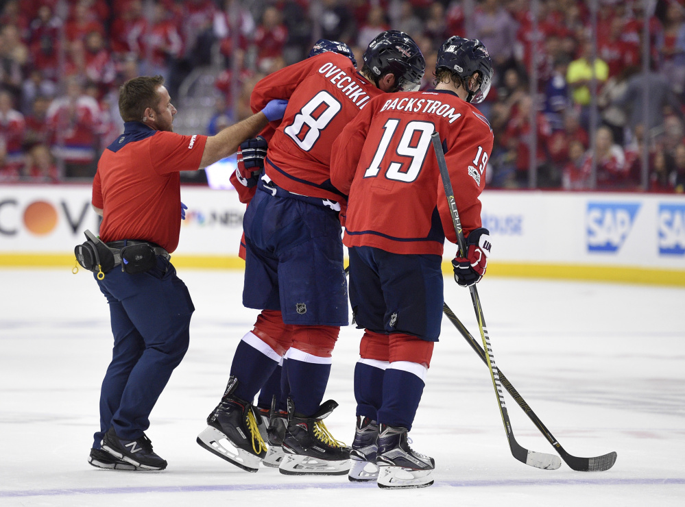 Capitals star Alexander Ovechkin is helped off the ice after he was injured in the first period Friday. Ovechkin missed the rest of the first period but returned in the second period.