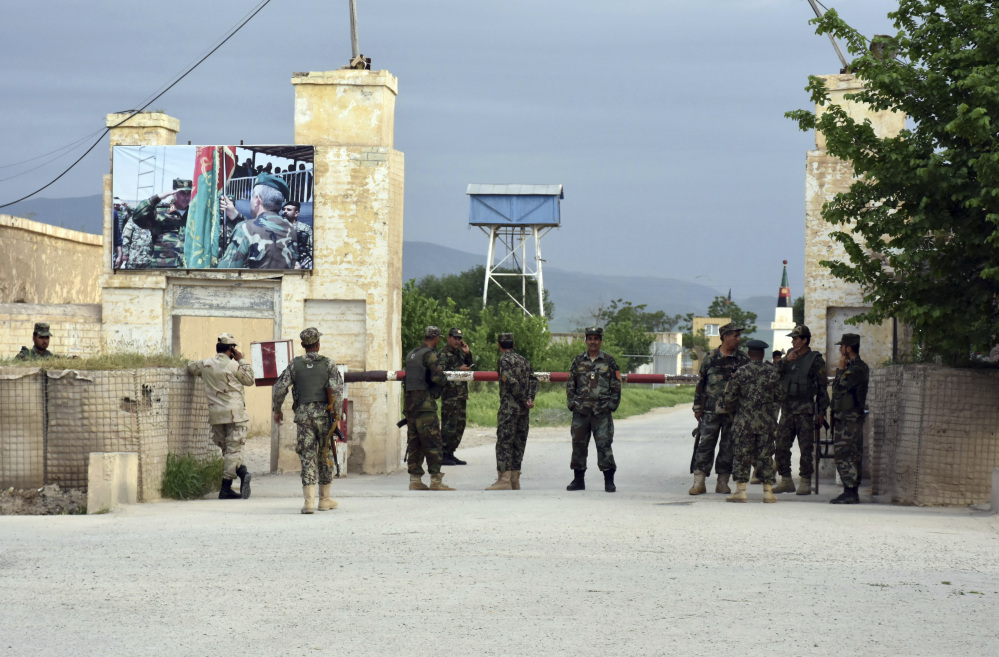 Afghan soldiers stand guard at the gate of a military compound after an attack by gunmen in Mazar-e- Sharif province north of kabul, Afghanistan, Friday, April 21, 2017. Gunmen wearing army uniforms stormed a military compound in the Balkh province, killing at least eight soldiers and wounding 11 others, an Afghan government official said Friday. (AP Photo/Mirwais Najand)