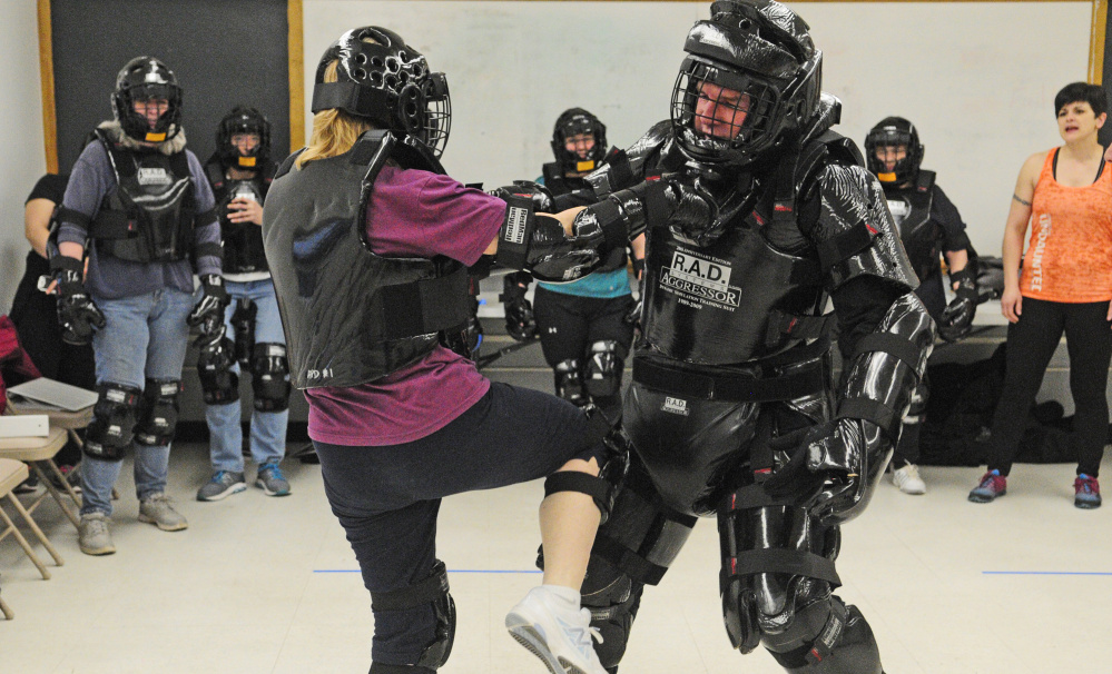 Ann Benson, 64, kicks a law enforcement officer playing an aggressor during a self-defense class.