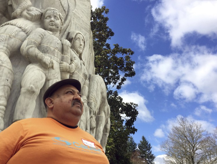 Moses Maldonado stands in front of a statue of pioneers at the Oregon Capitol in Salem, Ore. Maldonado attended a rally honoring farmworker organizer Cesar Chavez. in March.