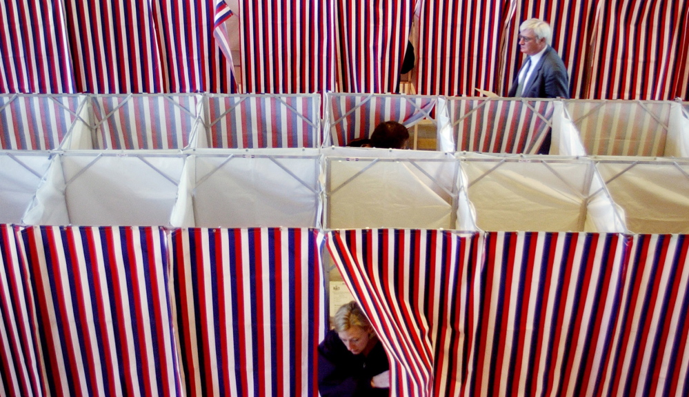Voters make their way in and out of voting booths at Kennebunk Town Hall on Election Day in 2002.
