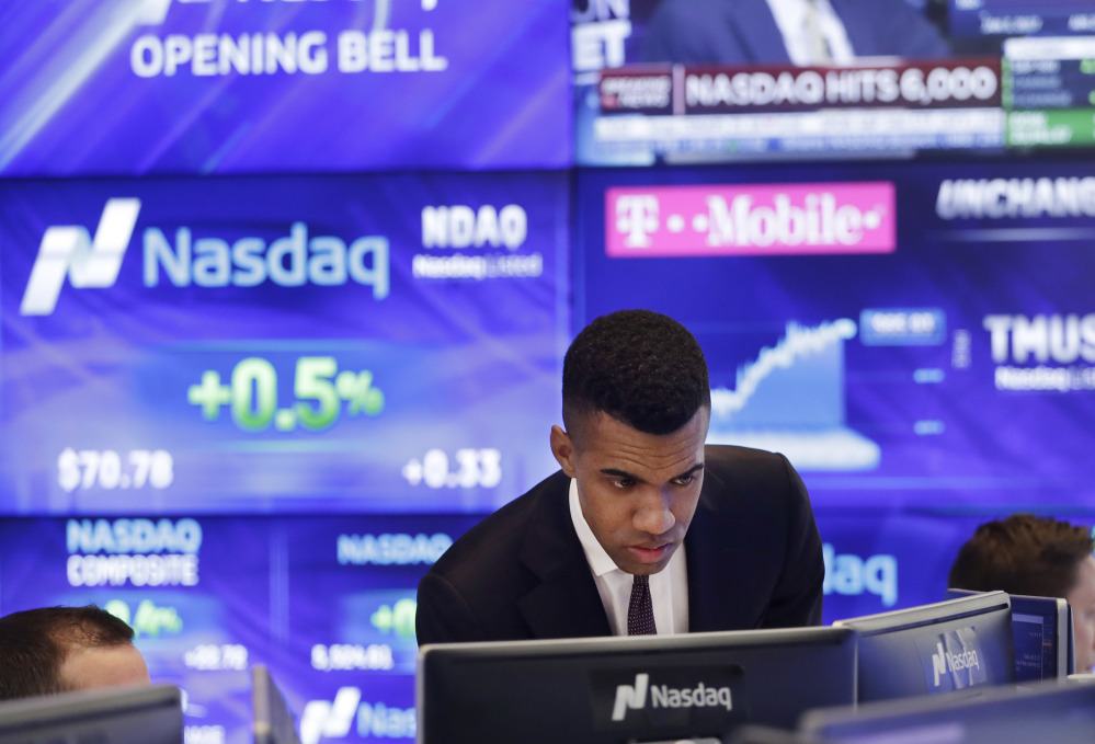 Brad Smith monitors stock prices at the Nasdaq MarketSite on Tuesday in New York. The Nasdaq Composite rose above 6,000 Tuesday, a record high.