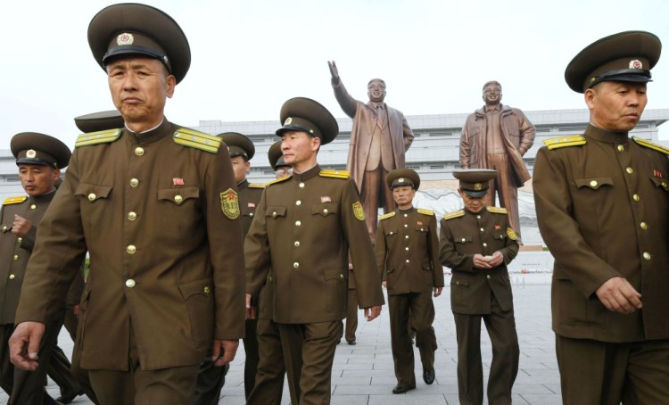 North Korean soldiers walk in front of bronze statues of North Korea's late founder Kim Il-sung and late leader Kim Jong Il at Mansudae in Pyongyang, in this photo released by Kyodo on Tuesday to mark the 85th anniversary of the founding of the Korean People's Army.
