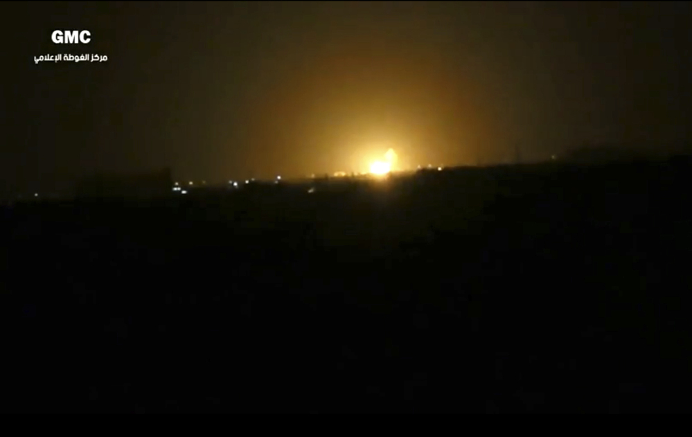This image from video provided by the Syrian anti-government activist group Ghouta Media Center, which has been authenticated based on its contents and other AP reporting, shows flames rising after an explosion near an airport west of Damascus, Syria, on Thursday.