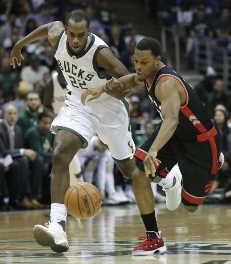 Khris Middleton, left of the Milwaukee Bucks and Kyle Lowry of the Toronto Raptors compete for a loose ball during the first half of Toronto's series-clinching victory Thursday night.